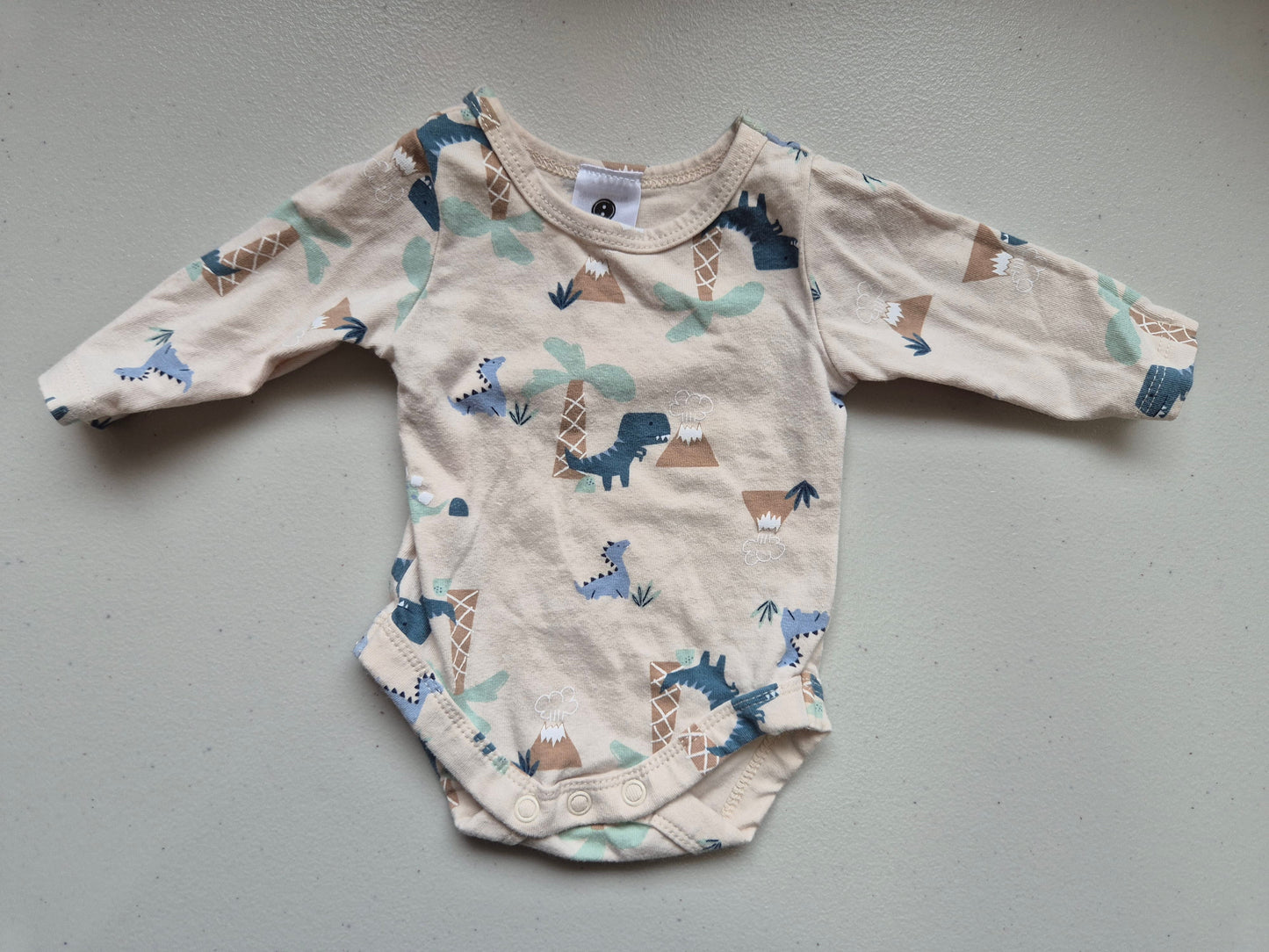 Baby onesie with animal pattern on a gray surface