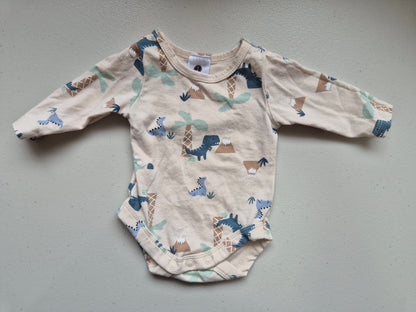 Baby onesie with animal pattern on a gray surface