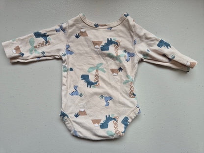 Baby onesie with animal pattern on a gray surface